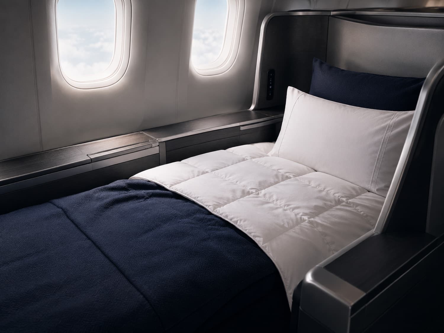 A quilted AIRLOOM duvet on a first-class cabin bed